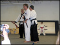 Photo of 6th Degree Master Rick Morad tying on the LTrain's Black Belt for the very first time.