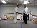 Photo of the LTrain bowing to 6th Degree Master Rick Morad after receiving his TKD Black Belt.